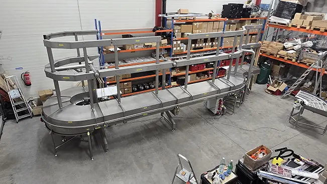 Stainless steel accumulation conveyor with guard rails, assembled in the workshop